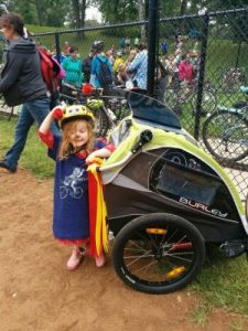 Small person leaning on a kid bike carrier