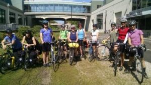 group of riders standing on greenway