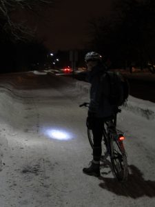 Jen on a wintery bike path with their bike