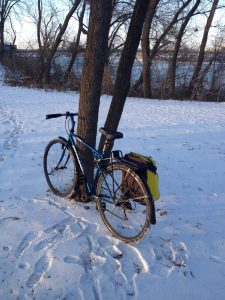 bike leaning against a tree in a winter and snowy setting