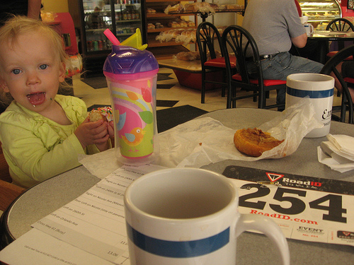 child at a table with drink cups around