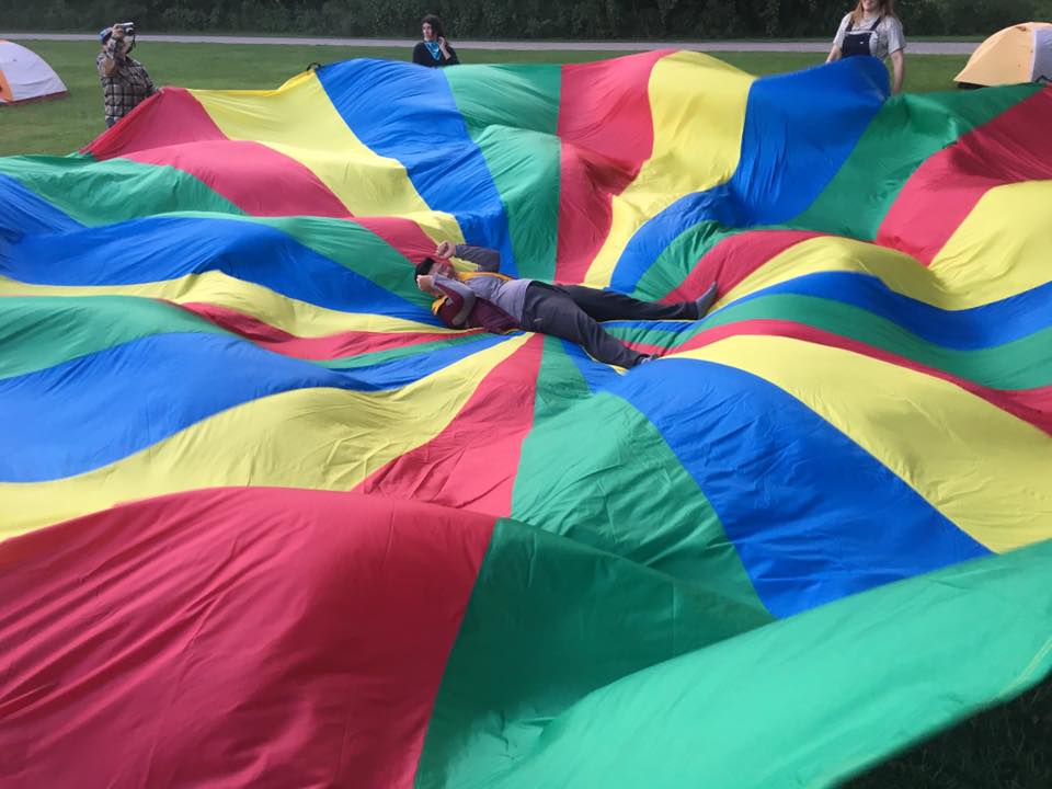 people playing with a giant parachute
