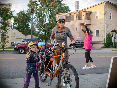 person on a bike with several children around