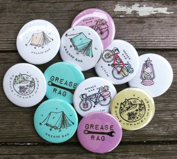 pile of grease rag buttons with camping illustration
