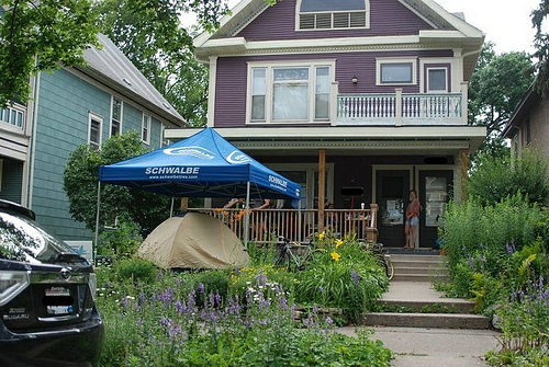 purple house with tent under a canopy in the front yard