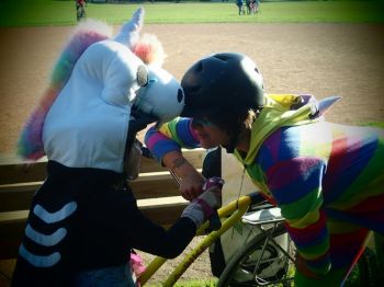two people press forheads together one in a unicorn helmet