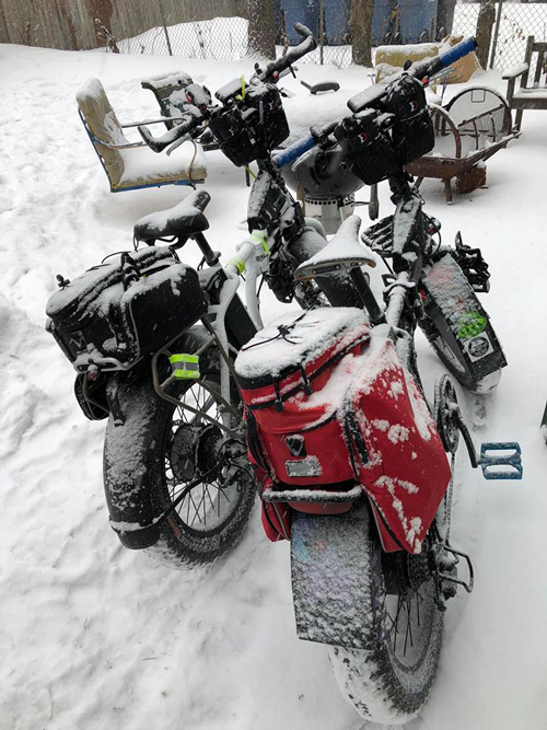 two e-bikes covered in snow