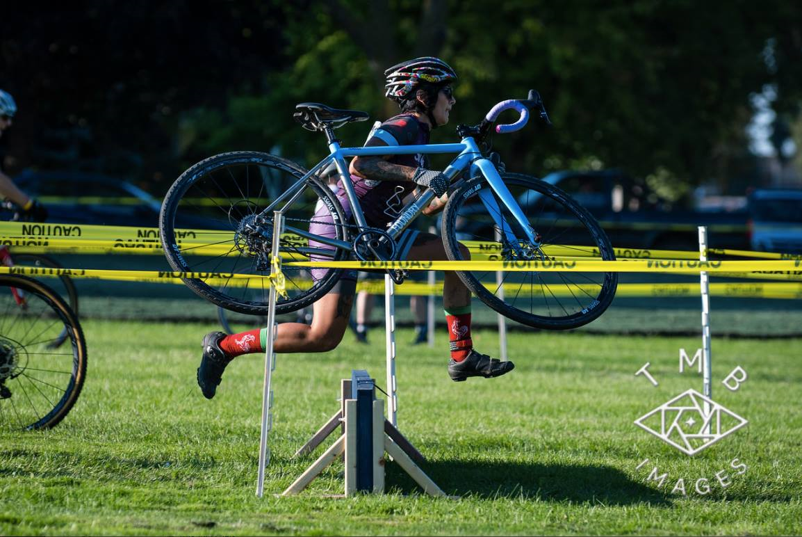 rider carrying bike over hurdle